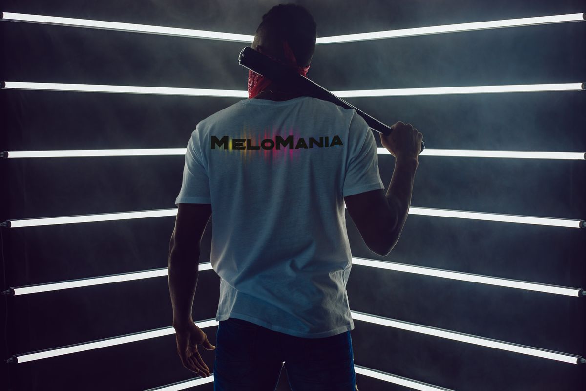 Un uomo di spalle con una T-shirt Melomania tra barre di luce bianca